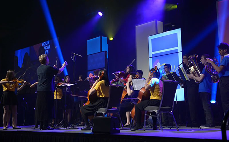 A photo of an orchestra on stage at the CBYA Gala.
