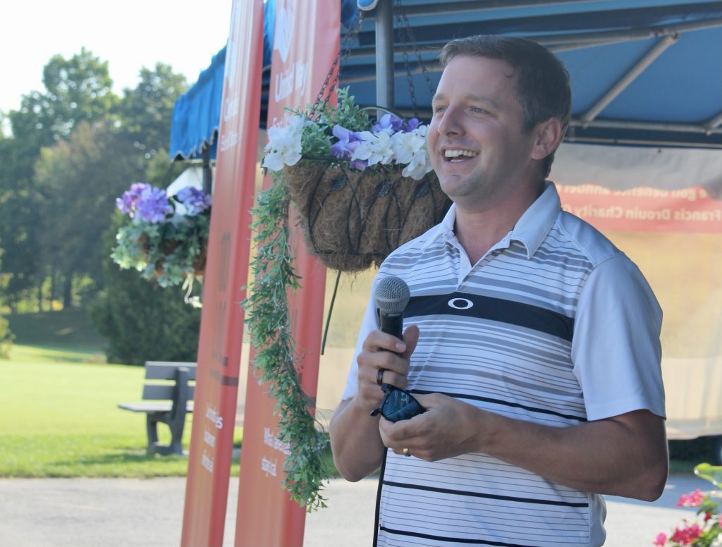 Francis Drouin at the mic greeting golfers