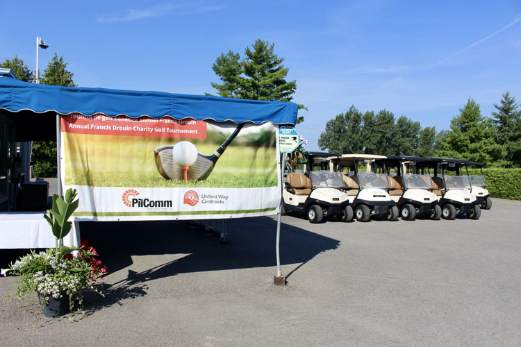 A photo of the registration tent set up next to some golf carts.