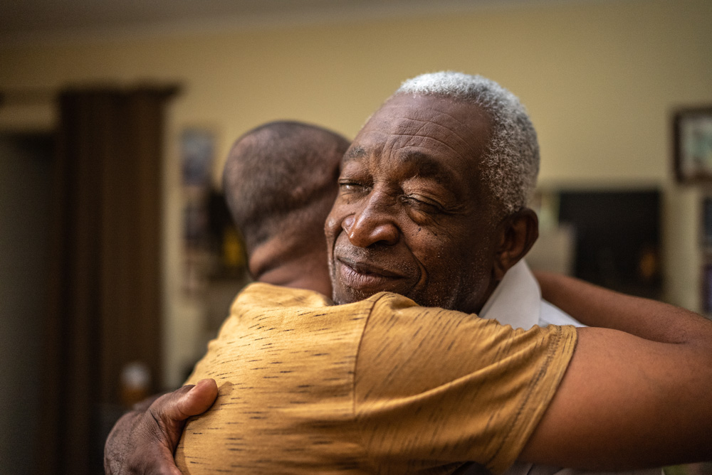 A photo of a grandpa hugging his grandson.