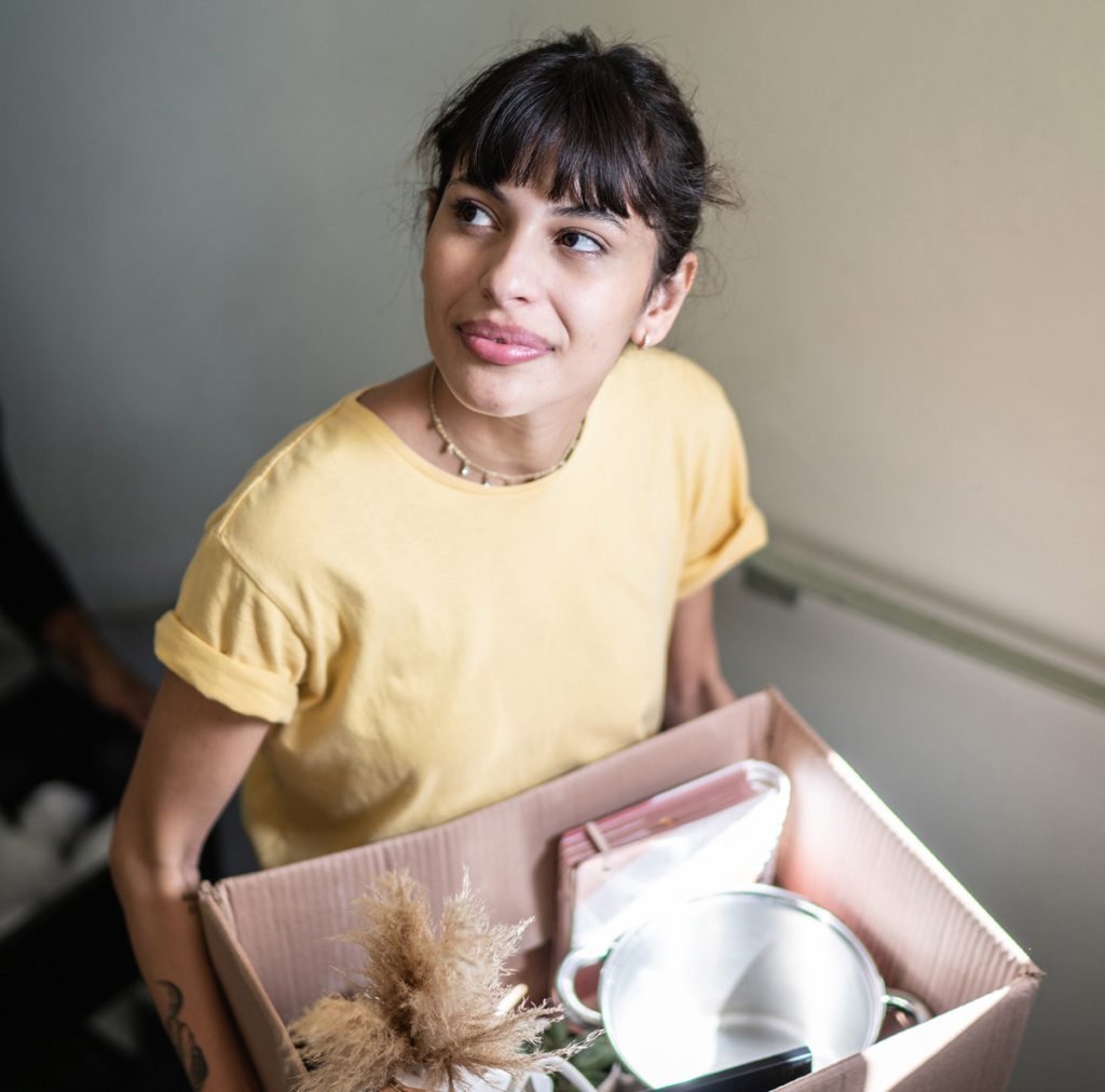 A photo of two friends chatting in a kitchen over coffee.