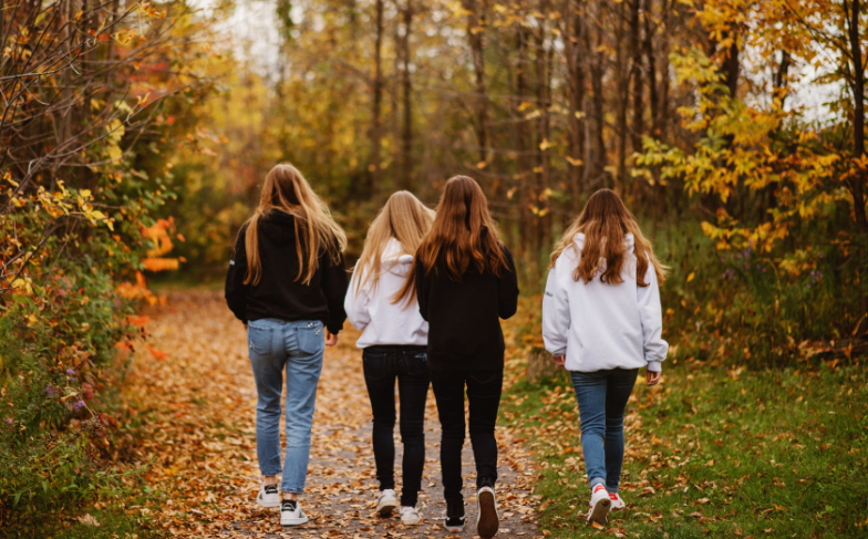 A photo of 4 youth walking down a path in the forest / Rural Youth Homelessness Network